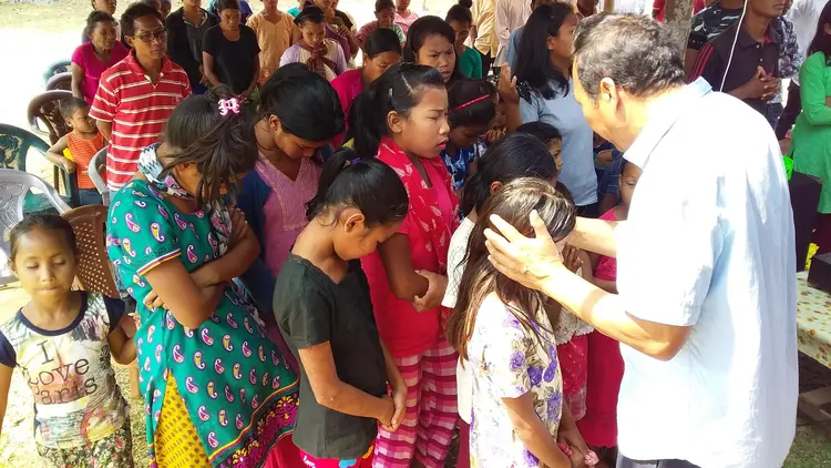 Mr. Sunmith G. Momin praying over the Students at Rongmasu Mission Field.