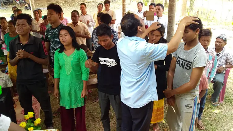 Mr. Sunmith G. Momin praying over the Students at Rongmasu Mission Field.